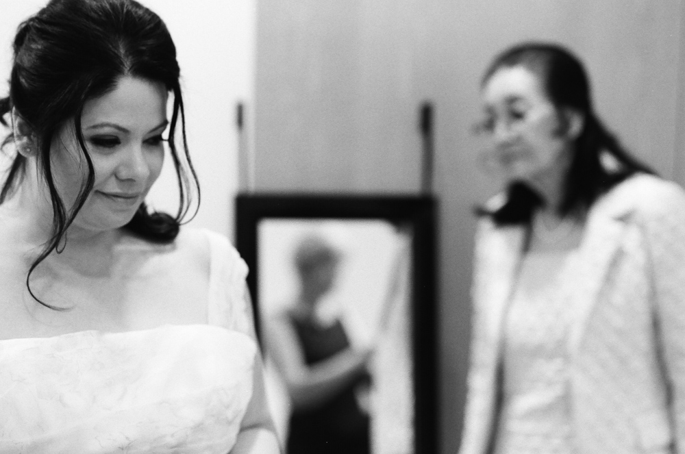 Bride, mom sand grandma look on in the mirror right before the wedding ceremony. - ©William Bay Photographic Arts