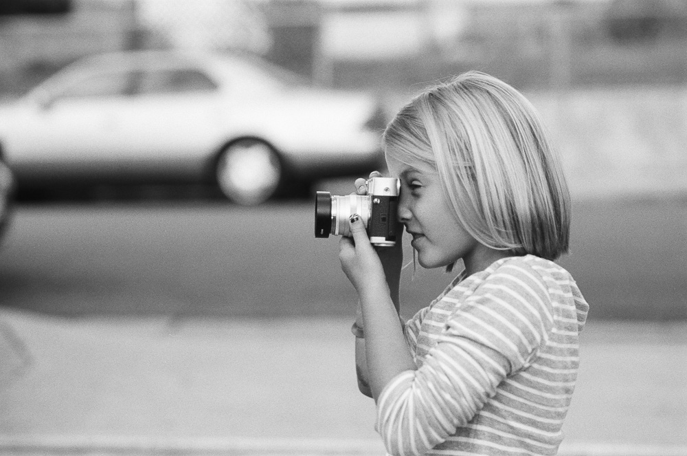 Close up of young girl (Alex) taking a picture. ©William Bay Photographic Arts.